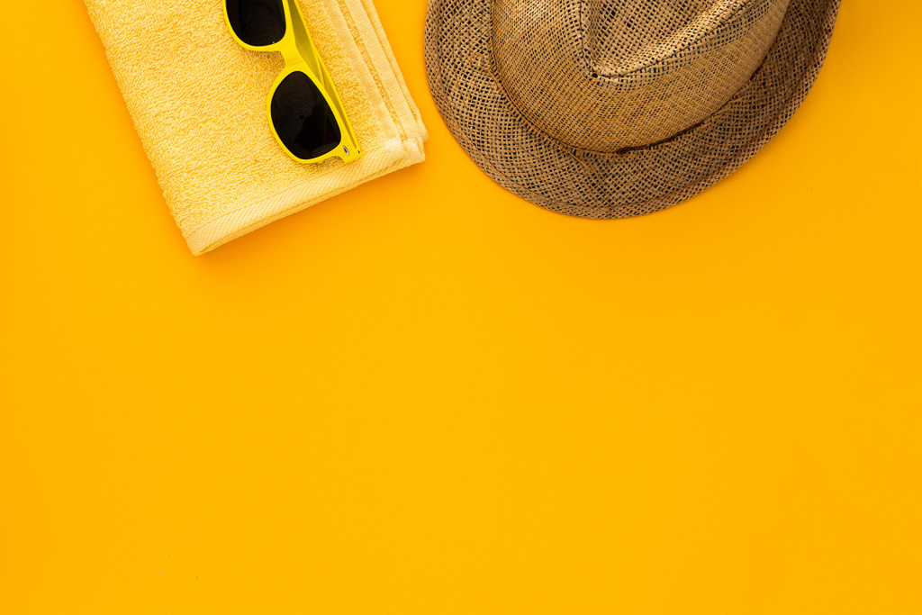 beach-accessories-yellow-background-sunglasses-towel-flip-flops-striped-hat.jpg